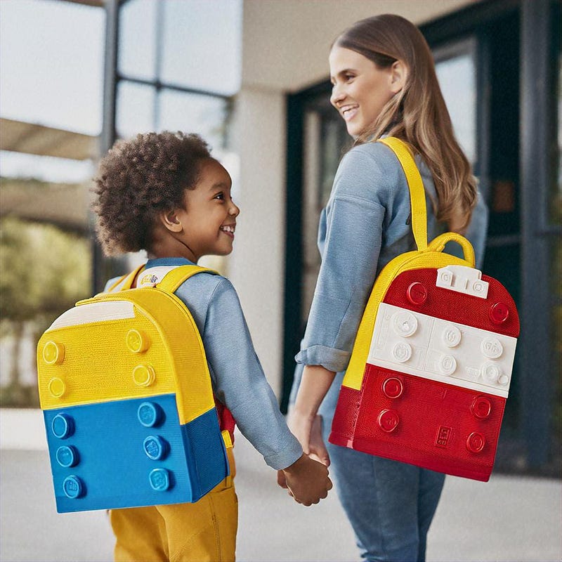Parents dropping kids at school with Lego Store branding